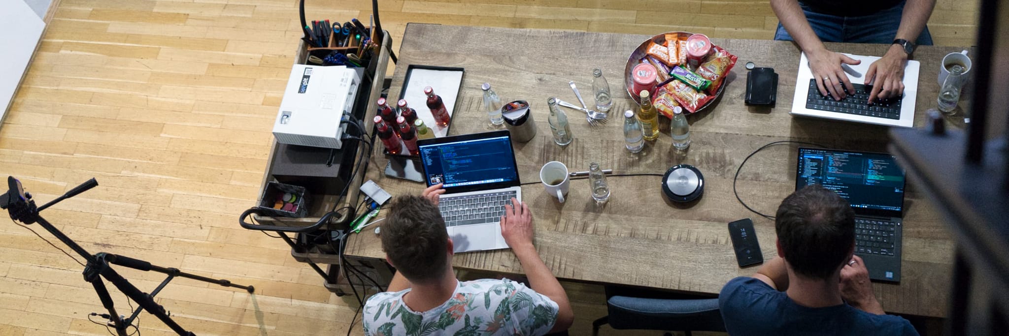 enpit-Programmierer sitzen mit Laptops an einem Tisch und programmieren
